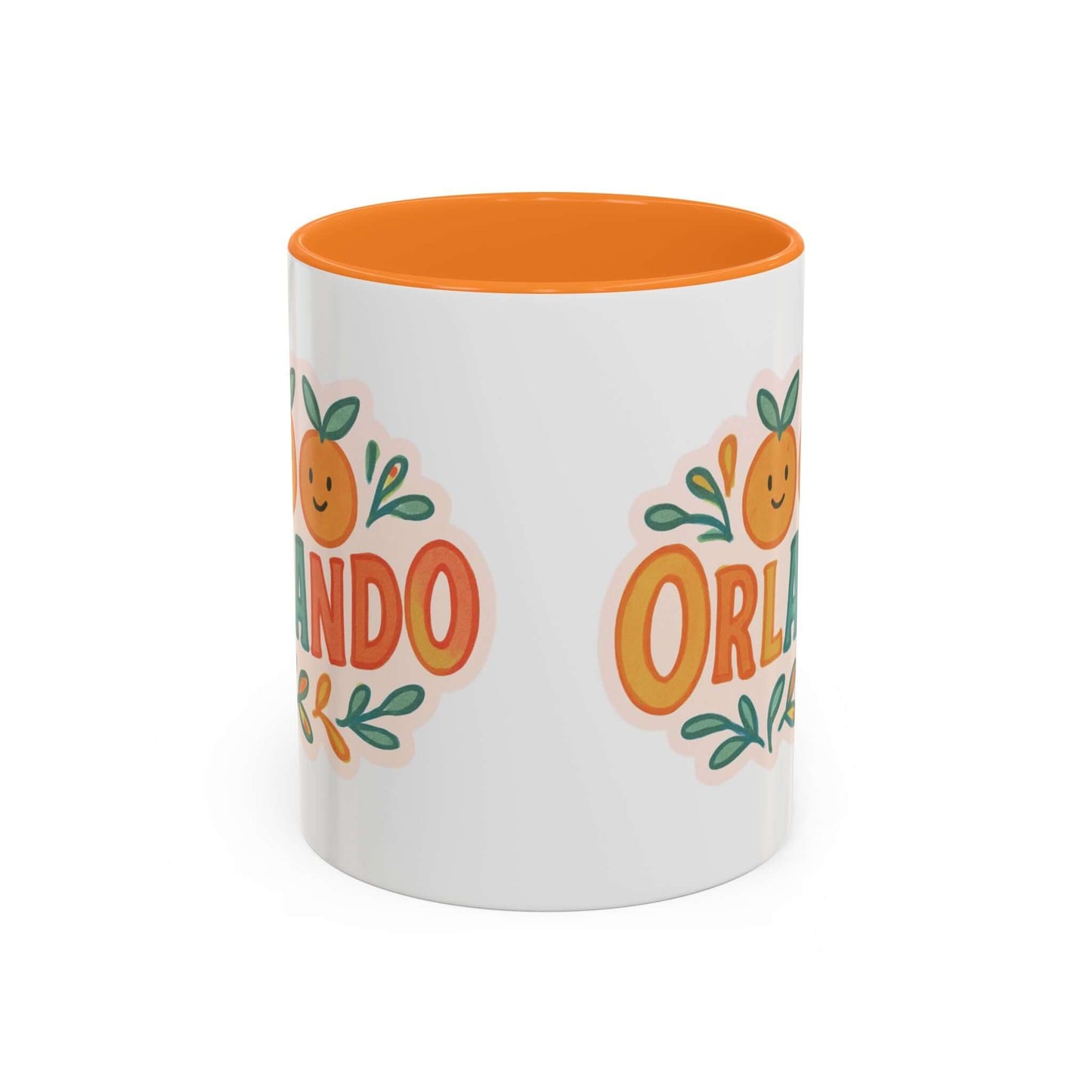 white ceramic mug with 'Orlando' written in orange lettering, accompanied by a graphic of orange and green leaves. The mug has a pink interior and handle.