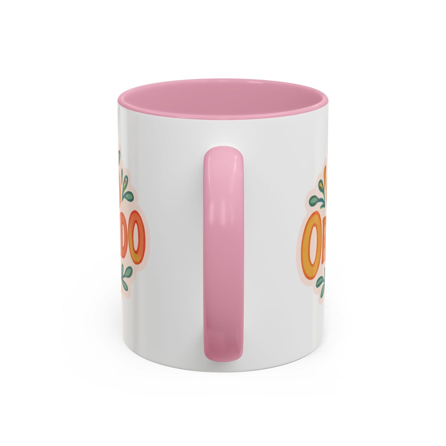 white ceramic mug with 'Orlando' written in orange lettering, accompanied by a graphic of orange and green leaves. The mug has a pink interior and handle.