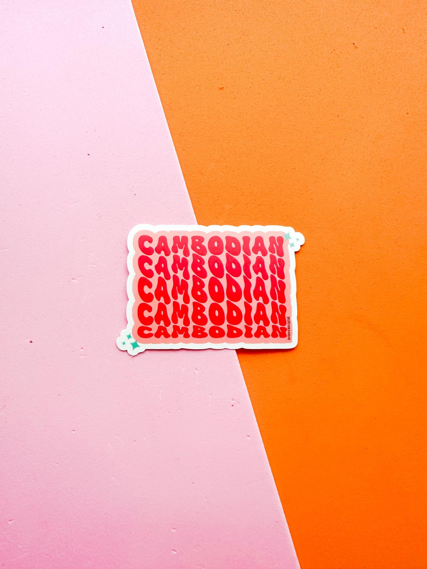 A matte premium vinyl sticker with the word 'CAMBODIA' in bold red letters on a pink background