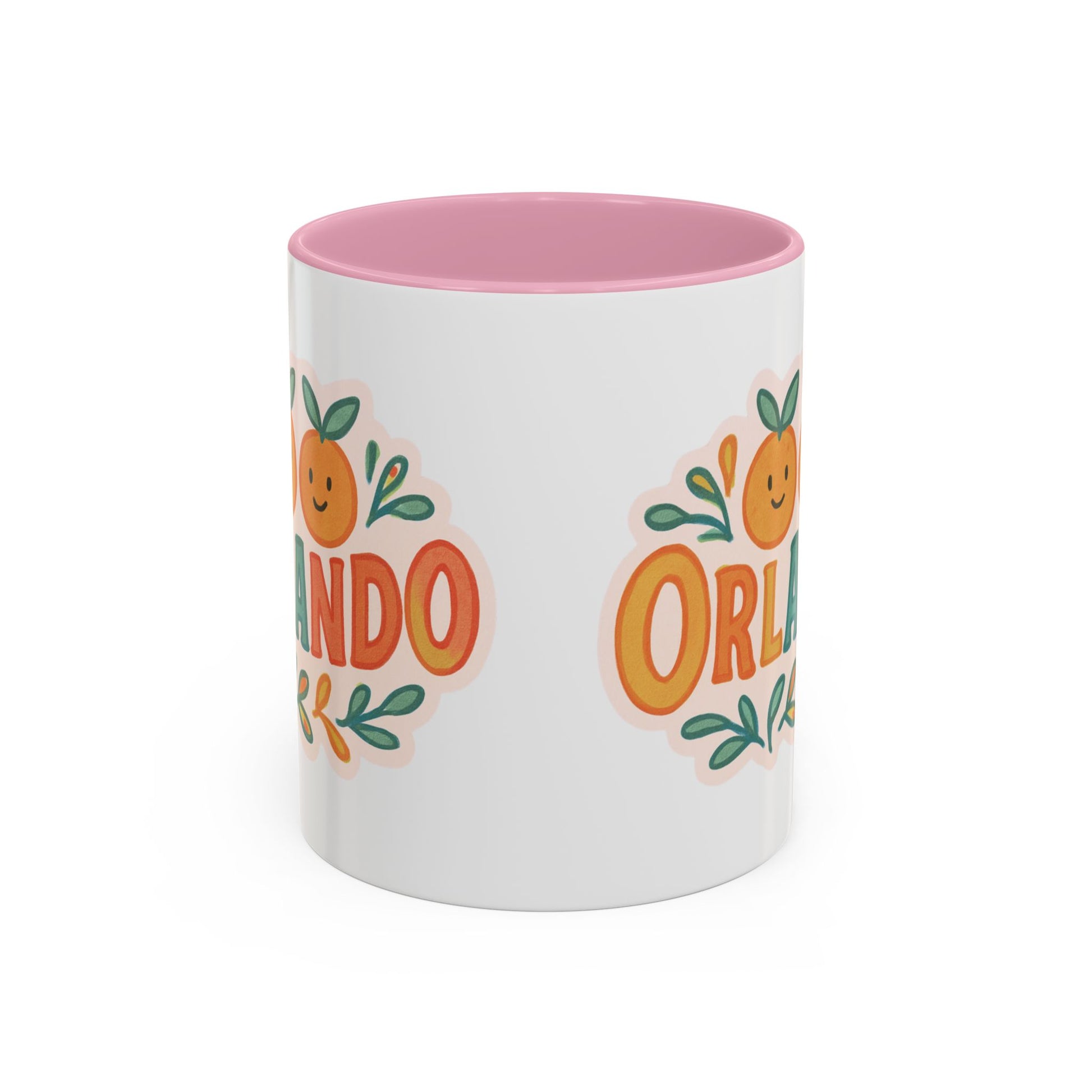 white ceramic mug with 'Orlando' written in orange lettering, accompanied by a graphic of orange and green leaves. The mug has a pink interior and handle.