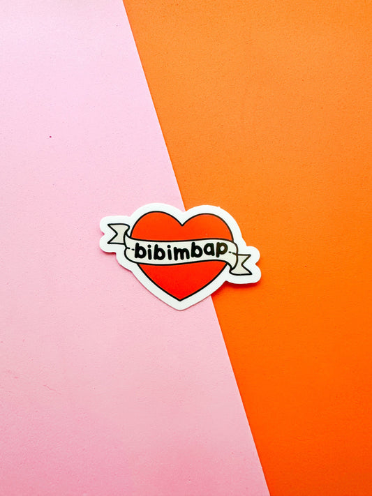 A vinyl sticker with a red heart and the text 'bibimbap' written inside 
