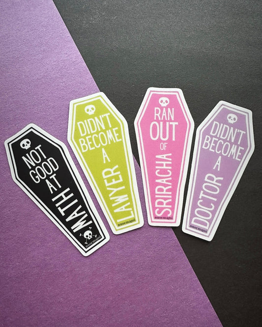 Four coffin-shaped stickers with humorous text