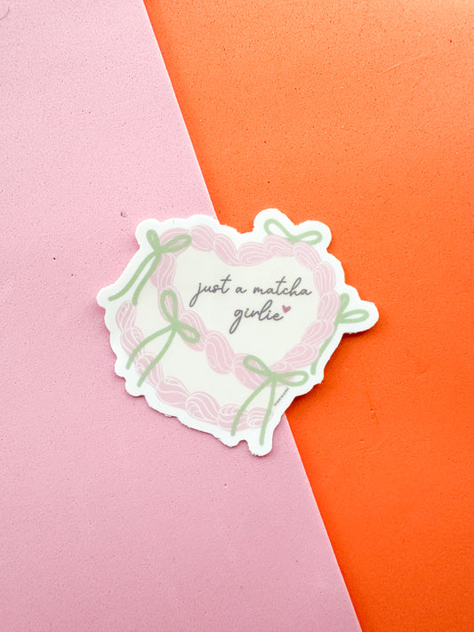 Sticker with 'just a matcha girl' text on a cake